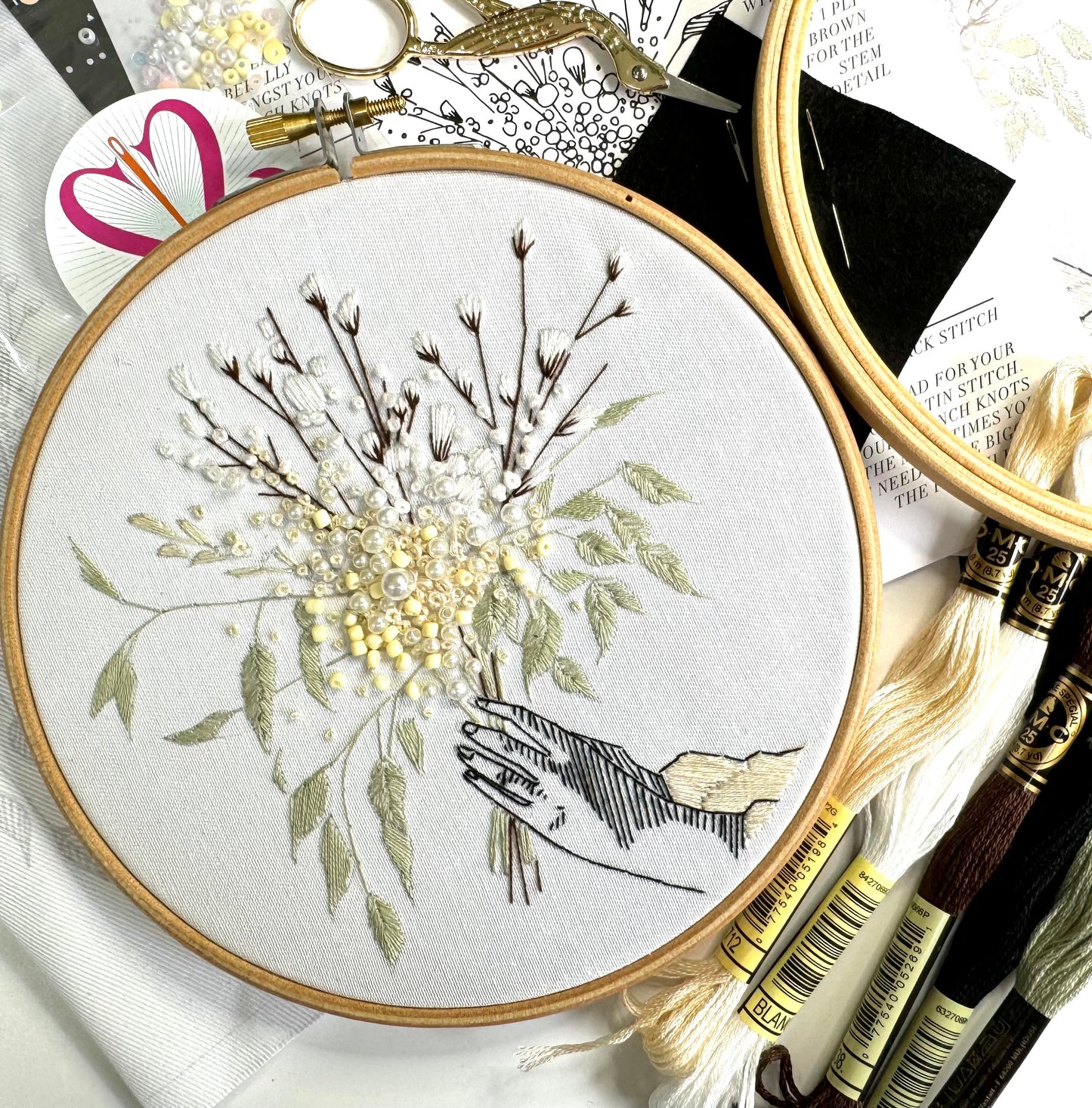 detail of winter embroidery kit with DMC threads and wooden hoop